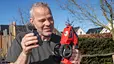 Ein Mann hält draußen ein rotes Akku-Gartengerät und ein abgenommenes Scherblatt in den Händen und lächelt. - Foto: Claudio Kalex Ein Mann hält draußen ein rotes Akku-Gartengerät und ein abgenommenes Scherblatt in den Händen und lächelt. - Foto: Claudio Kalex