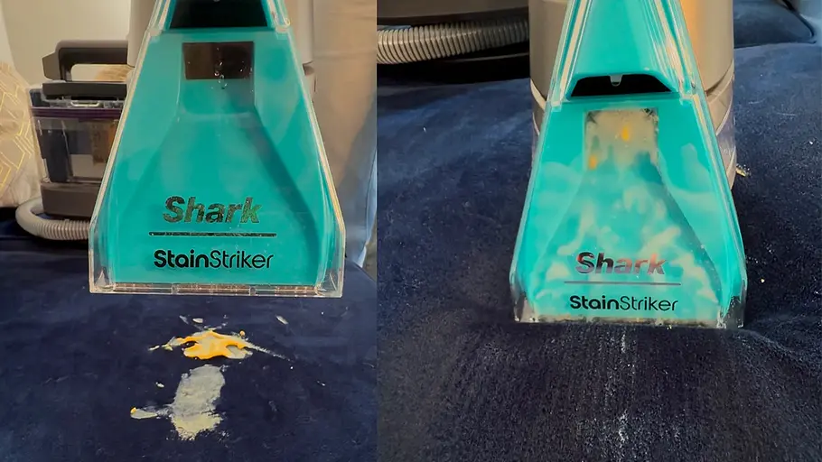 Aufsatz des Shark StainStriker wird vor einem frischen Fleck auf einem blauen Sofa platziert. Shark StainStriker entfernt frische Flecken vom Sofa – Testbericht und Anwendung