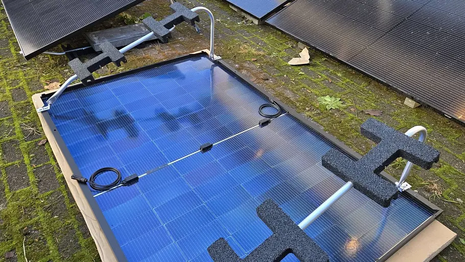 Ein bläuliches Solarmodul liegt auf dem Rücken, weiße Ständer sind erkennbar. 
