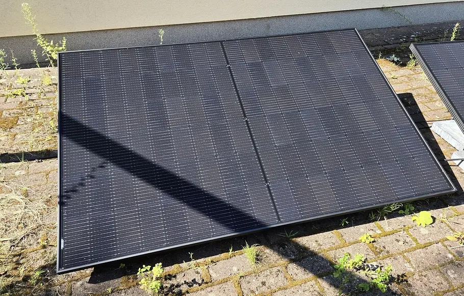 Solarmodul auf einer Veranda mit dem Schattenwurf eines Balkens darauf.