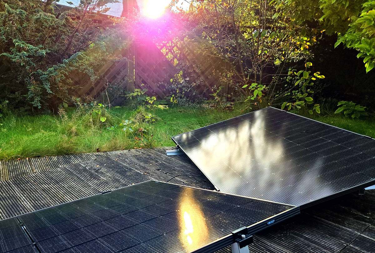 Zwei Solarmodule stehen im Garten, im Hintergrund ist die Sonne zu sehen