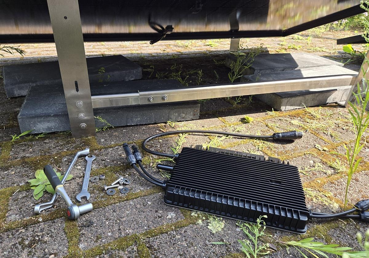 Wechselrichter-Installation am Balkonkraftwerk Ein Wechselrichter samt Werkzeug liegt unter einem Balkonkraftkwerk