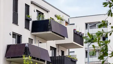 Balkon-Sonnenkollektoren für Mehrfamilienhäuser, die Häuser sind weiß und haben alle Balkone, hier sind dunkle Solarpanels angebracht. Der Himmel ist blau. - Foto: istockphoto.com / Maryana Serdynska Balkon-Sonnenkollektoren für Mehrfamilienhäuser, die Häuser sind weiß und haben alle Balkone, hier sind dunkle Solarpanels angebracht. Der Himmel ist blau. - Foto: istockphoto.com / Maryana Serdynska