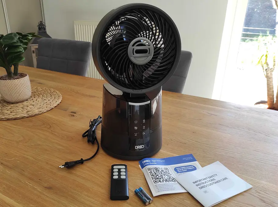 DREO Nebelventilator im Test Der DREO TuroboCool Nebelventilator steht mit Fernbedienung, Batterien und Anleitung auf einem Wohnzimmertisch.