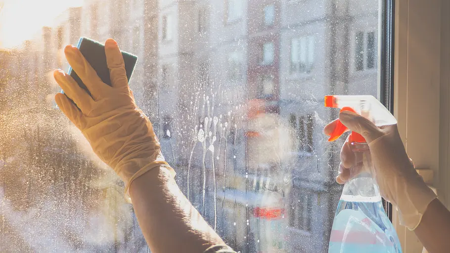 Auf eine stark verschmutzte Fensterscheibe wird gebrauchsfertiger Glasreiniger aufgetragen und mit einem Schwamm verteilt