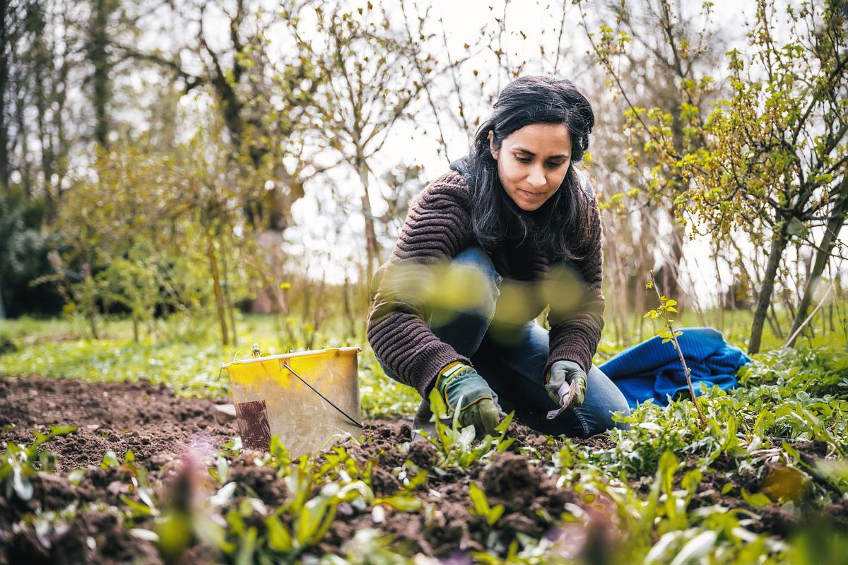 Frau macht Gartenarbeit und nutzt Gartenzubehör
