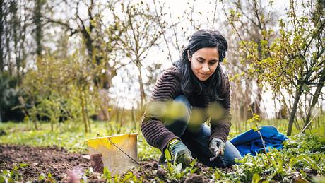 Frau macht Gartenarbeit und nutzt Gartenzubehör - Foto: golero / iStock