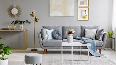 Eine dunklegraue Wand und ein graues Sofa, dazu ein goldener Spiegel, Bilderrahmen und Lampen - Foto: iStock / KatarzynaBialasiewicz Eine dunklegraue Wand und ein graues Sofa, dazu ein goldener Spiegel, Bilderrahmen und Lampen - Foto: iStock / KatarzynaBialasiewicz