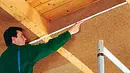 Mann misst am Dachgeschoss Mann misst am Dachgeschoss