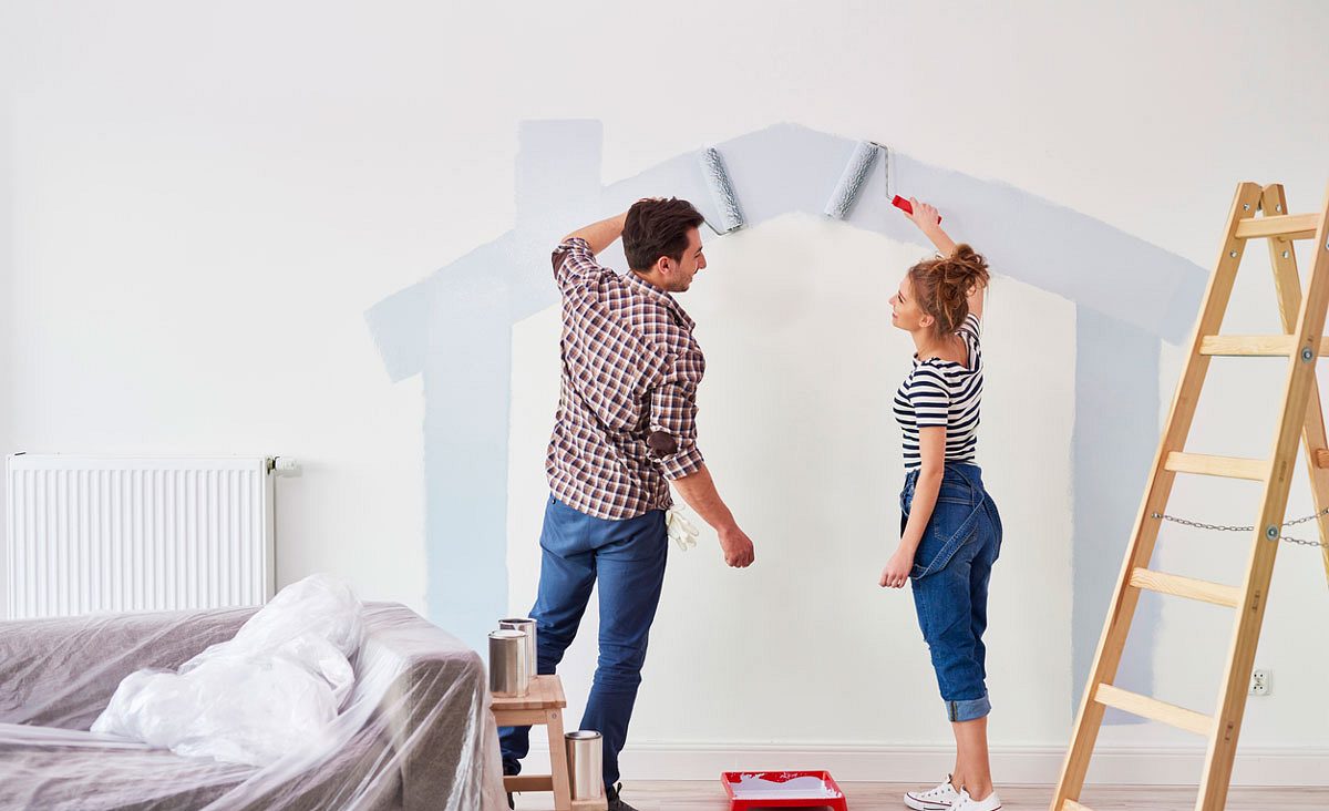 Paar malt Haus an Wand