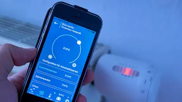 Ein Smartphone mit einer App ist im Vordergrund, dahinter sieht man einen Heizkörper. - Foto: Imago/ Kosecki Ein Smartphone mit einer App ist im Vordergrund, dahinter sieht man einen Heizkörper. - Foto: Imago/ Kosecki