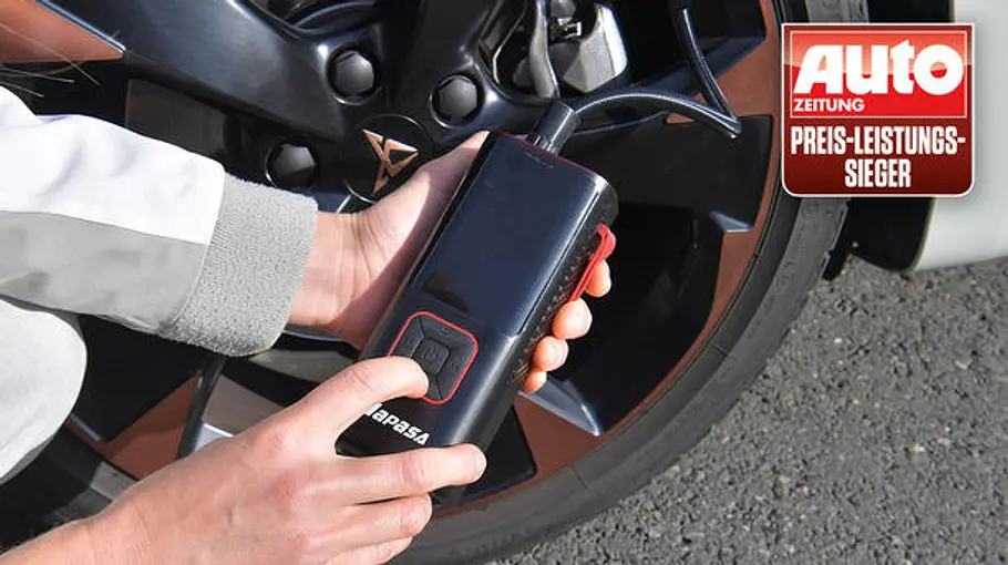 Eine Person hält eine schwarze Napasa-Akku-Luftpumpe mit Display am Reifen; Auto Zeitung Preis-Leistungs-Sieger-Logo sichtbar.