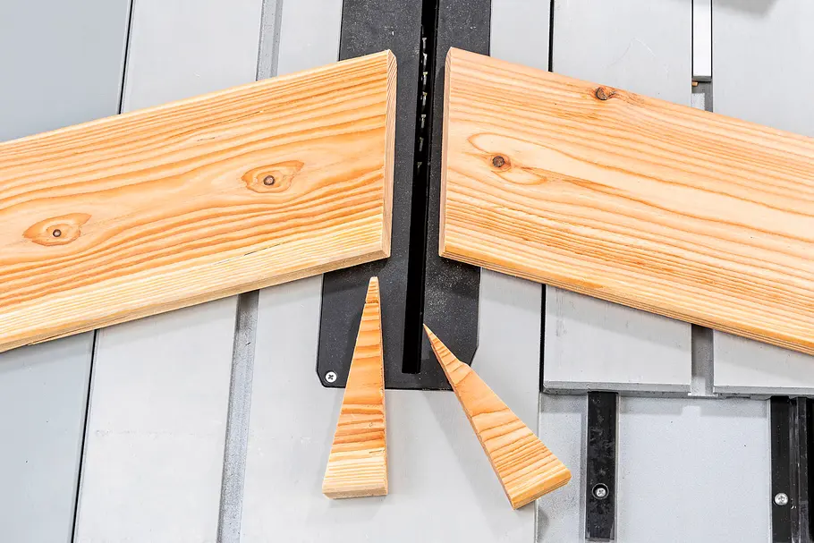 Gartendusche bauen Zwei Holzlatten werden an einem schwarzen Winkel ausgerichtet, darunter liegen zwei dreieckige Holzabschnitte.