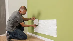 Mann klebt Stuck-Elemente an die Wand - Foto: sidm / MMM Mann klebt Stuck-Elemente an die Wand - Foto: sidm / MMM