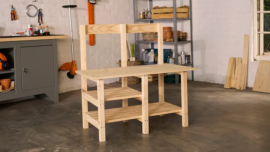 Matschküche: Rahmen Der fast fertig montierte Rahmen der Matschküche steht mit drei Ebenen und Rückwand aus Holz in einer Werkstatt.