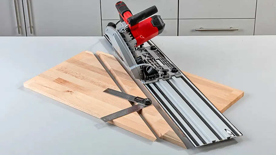 Verdrehter Hocker Eine Tauchsäge mit Führungsschiene und ein verstellbarer Metallwinkel liegen auf zwei schräg zugeschnittenen Holzplatten.