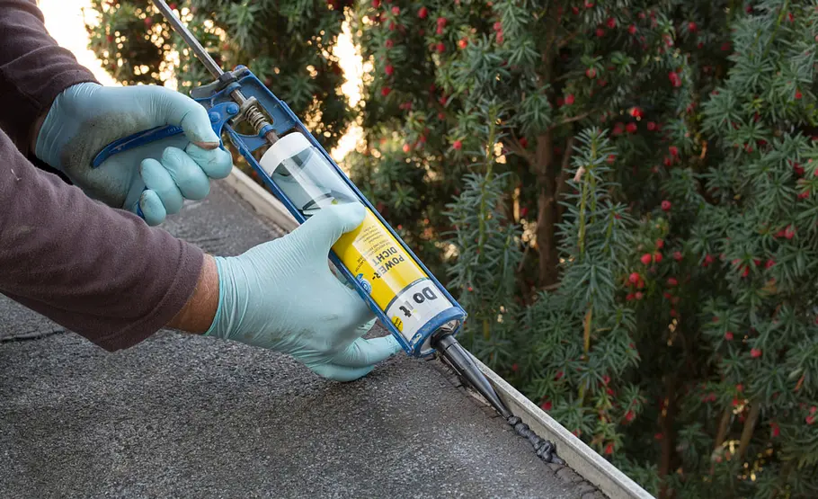 Der Übergang zwischen Flachdach und Dachaufkantung wird mit einer schwarzen Polymer-Dichtmasse ausgespritzt