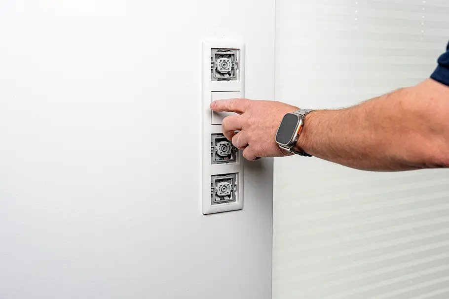 Smarte Beschattung Fertig installierter Smart-Home-Schalter zur Steuerung von Rollläden oder Sonnenschutzsystemen wird an einer Innenwand bedient.