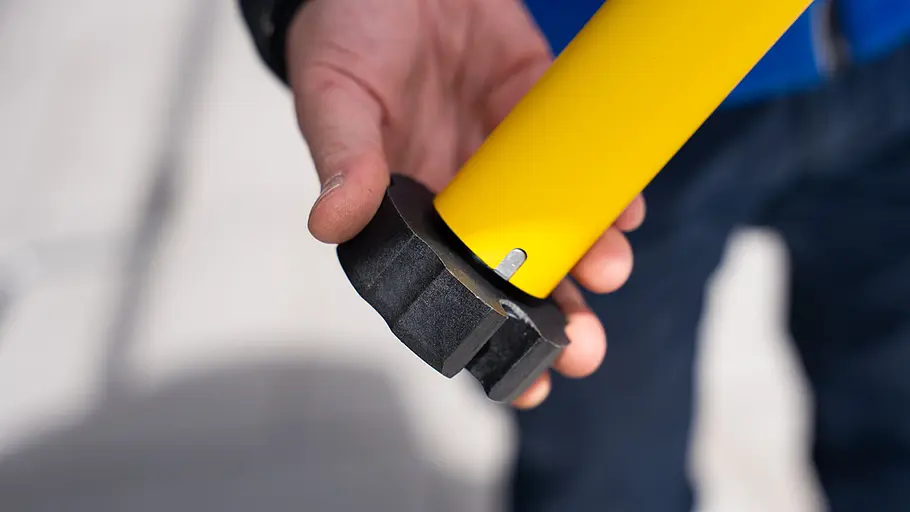 Kupplungsadapter Ein schwarzer Kupplungsadapter ist auf das Ende eines gelben Markisenmotors aufgesteckt und wird in einer Hand gehalten.