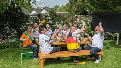 Freunde beim Feiern auf Sitzbänken im Garten - Foto: sidm / KEH