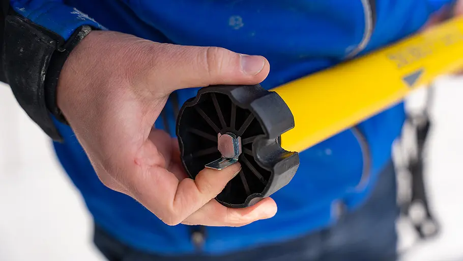 Kupplungsadapter Sicherung Eine Hand drückt einen Metall-Splint zur Sicherung in die Öffnung eines schwarzen Kupplungsadapters am Markisenmotor.