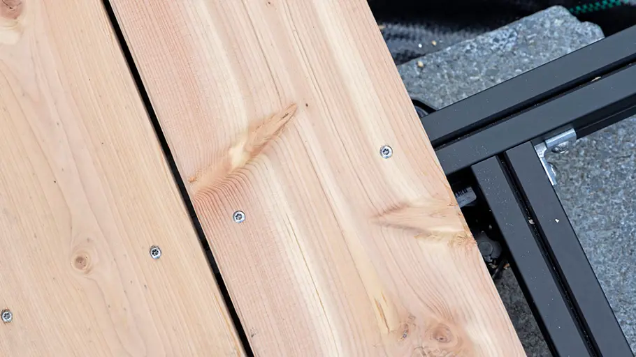 Terrasse gestalten Verschraubte Holzdielen liegen gerade nebeneinander auf einer Unterkonstruktion zur Fertigstellung der Terrasse.