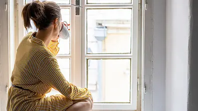 Frau sitzt am Fenster mit Tasse - Foto: iStock/StockRocket Frau sitzt am Fenster mit Tasse - Foto: iStock/StockRocket