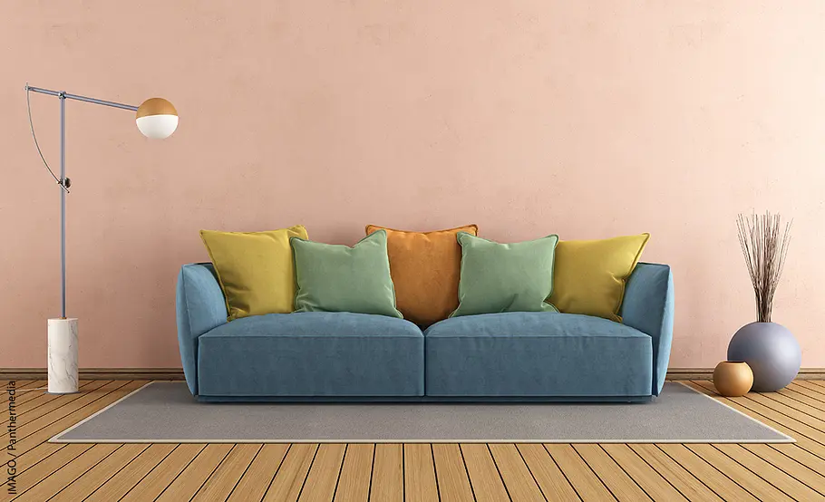 Blaue Couch mit Kissen in Rot, Grün und Gelb