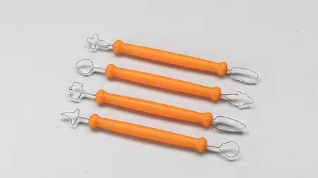 Schlingenwerkzeuge zum Schnitzen von Kürbissen. Die Griffe sind wie orangene Finger mit schwarzen Nägeln geformt.