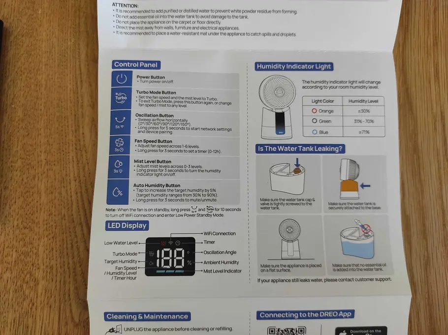 Kurzanleitung für Feuchtigkeitsanzeige und Gerätedisplay. Ein Ausschnitt aus der Kurzanleitung des DREO TurboCool Nebelventilator liegt auf einem Holztisch.