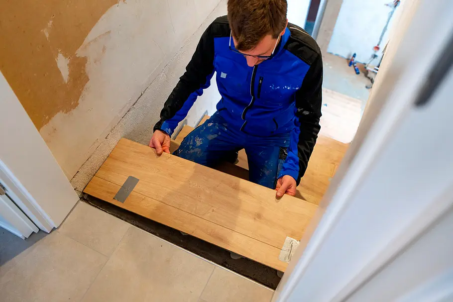 Laminatstück wird an der unteren Treppenstufe ausgerichtet und vorbereitet.