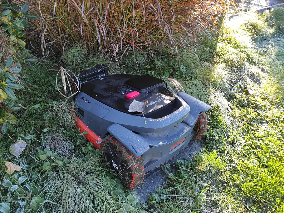 Trotz großen Reifen mit viel Profil stellte weicher Boden den Mäher immer wieder vor Herausforderungen. Mähroboter der Marke Segway auf seiner Ladestation.