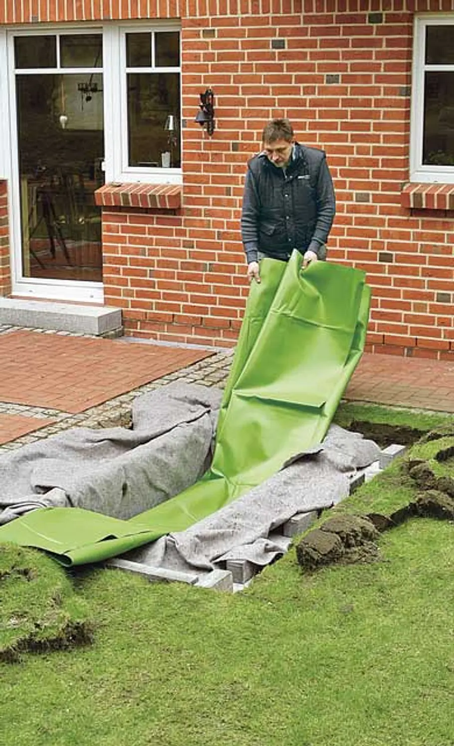 Mini-Teich bauen Teichfolien zur Mitte hin zusammenlegen und in Teichgrube ablassen