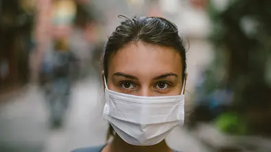 Frau mit Mundschutz - Foto: Popartic / iStock