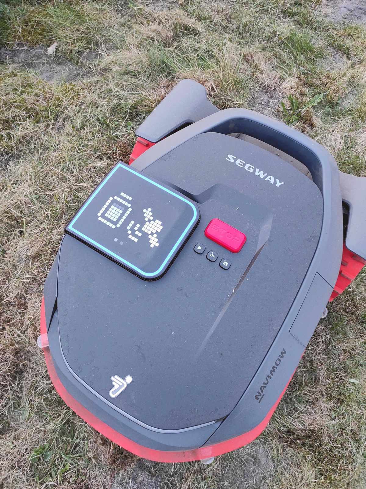 Mähroboter der Marke Segway zeigt ein leuchtendes Display mit einem Akku- und einem GPS-Symbol.