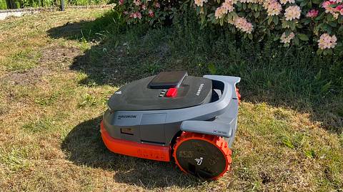 Mähroboter der Marke Segway Navimow fährt auf einer Rasenfläche. Im Hintergrund blühen Rhododendren.  - Foto: selbst.de/ Jessica Jansen