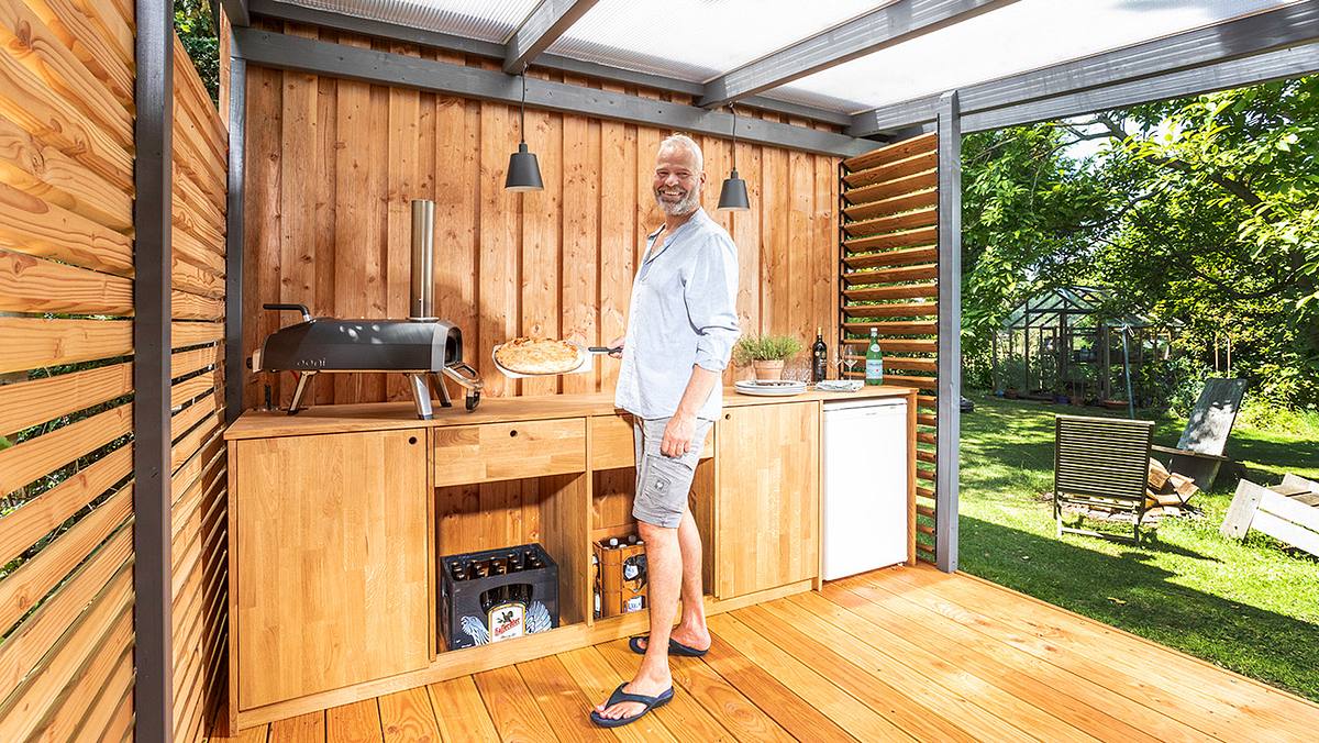 Ein überdachter Grillplatz mit einer Outdoor-Küche, in der gegrillt und Mahlzeiten im Freien zubereitet werden können.