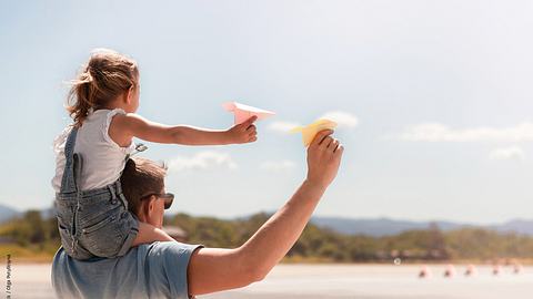 Papierflugzeuge können Sie auch mit Kindern basteln. - Foto: iStock / Olga Potylitsyna