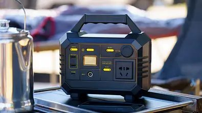 Eine typische Powerstation steht auf einem Campingkocher, es sind Anschlüsse und Bedienfelder zu erkennen - Foto: istockphoto.com / Jirasak Puttanaboon