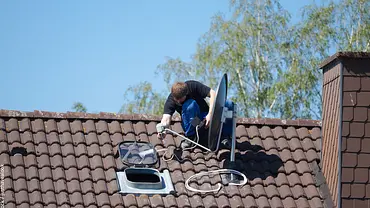 Die Satellitenschüssel wird häufig auf dem Dach angebracht. - Foto: iStock / justhavealook Die Satellitenschüssel wird häufig auf dem Dach angebracht. - Foto: iStock / justhavealook