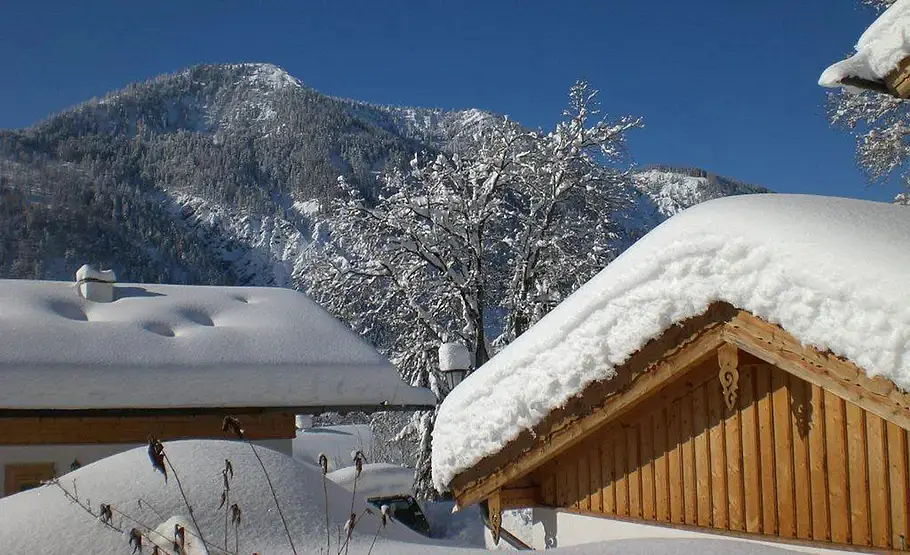 Auf einem Dach liegt eine etwa halben Meter dicke Schneeschicht