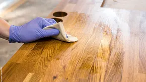 Schneidebrett aus Holz wird mit Tuch geölt - Foto: iStock / Helin Loik-Tomson Schneidebrett aus Holz wird mit Tuch geölt - Foto: iStock / Helin Loik-Tomson