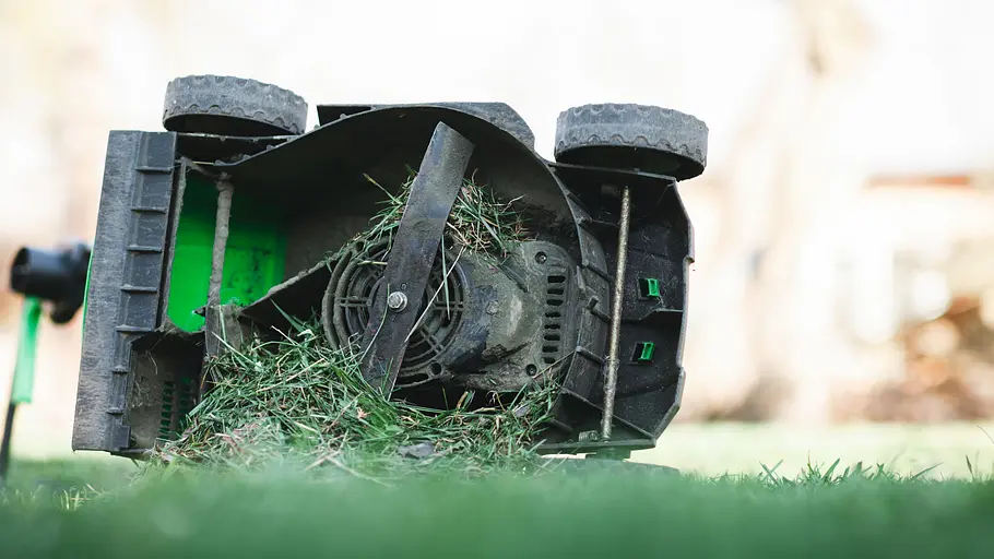 Mähdeck eines Rasenmähers Der Rasenmäher liegt auf der Seite, so dass man das Mähdeck des Mähers von unten sieht: Grasschnitt droht das Mähwerk zu verstopfen!