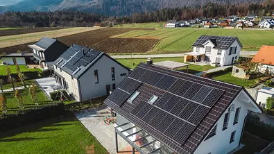 Niedrige Luftnahaufnahme neue dichte ländliche Wohnsiedlung, meist graue Dächer, etwas grüne Landschaftsgestaltung, junge Bäume. Moderne Häuser mit Flachdach - Foto: istockhphoto.com / Ziga Plahutar