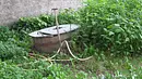 Unkraut im Garten neben alter Wanne, Spaten, Schlauch Unkraut im Garten neben alter Wanne, Spaten, Schlauch