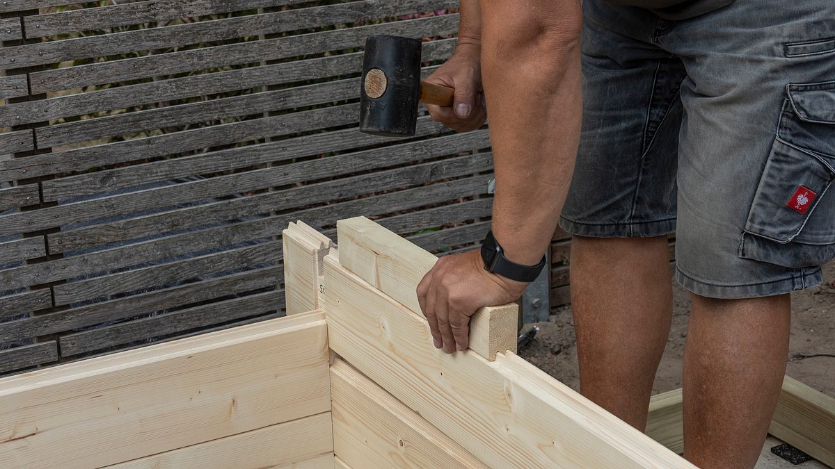 Verbindung der Wandbohle zusammenklopfen