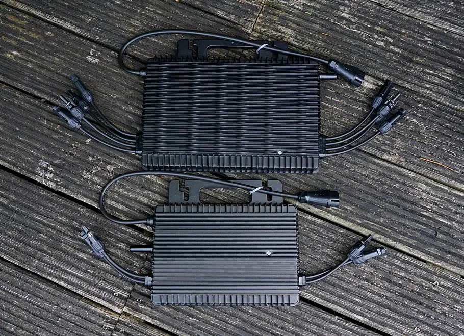 Zwei Wechselrichter von Hoymiles mit 1600 und 800 Watt Zwei Wechselrichter von Hoymiles mit 1600 und 800 Watt liegen auf einem Holzboden