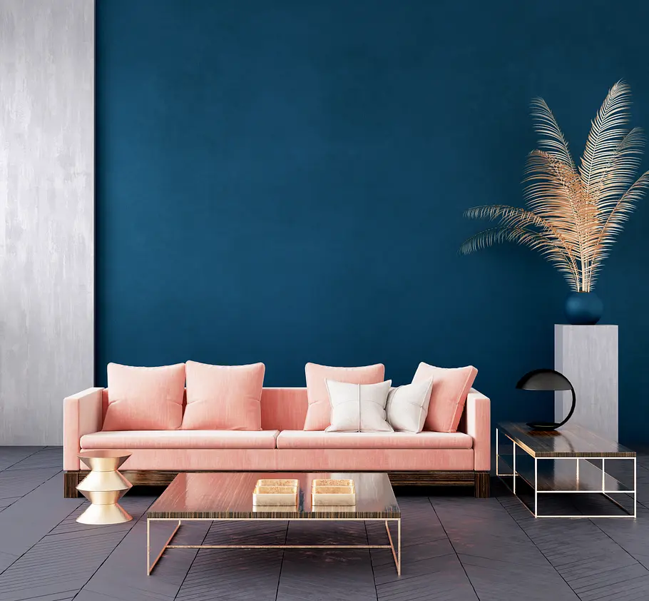 Ein rosa Sofa vor einer blauen Wand