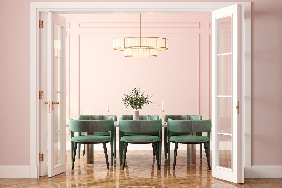 Ein rosa gestrichenes Esszimmer mit grünen Stühlen