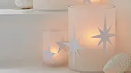 Filigrane Weihnachts-Windlichter aus weißem Transparentpapier vor Tannenzapfen-Deko - Foto: Hersteller / tesa SE Filigrane Weihnachts-Windlichter aus weißem Transparentpapier vor Tannenzapfen-Deko - Foto: Hersteller / tesa SE
